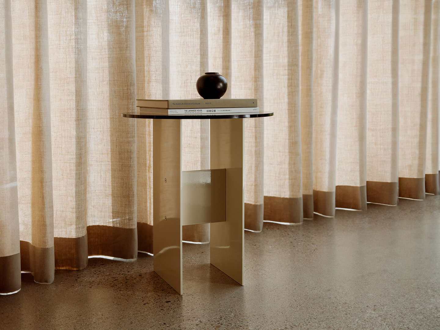 Material Studies I Side Table in lime-white aluminum, bronzed-glass top, by linen curtains with a dark sphere