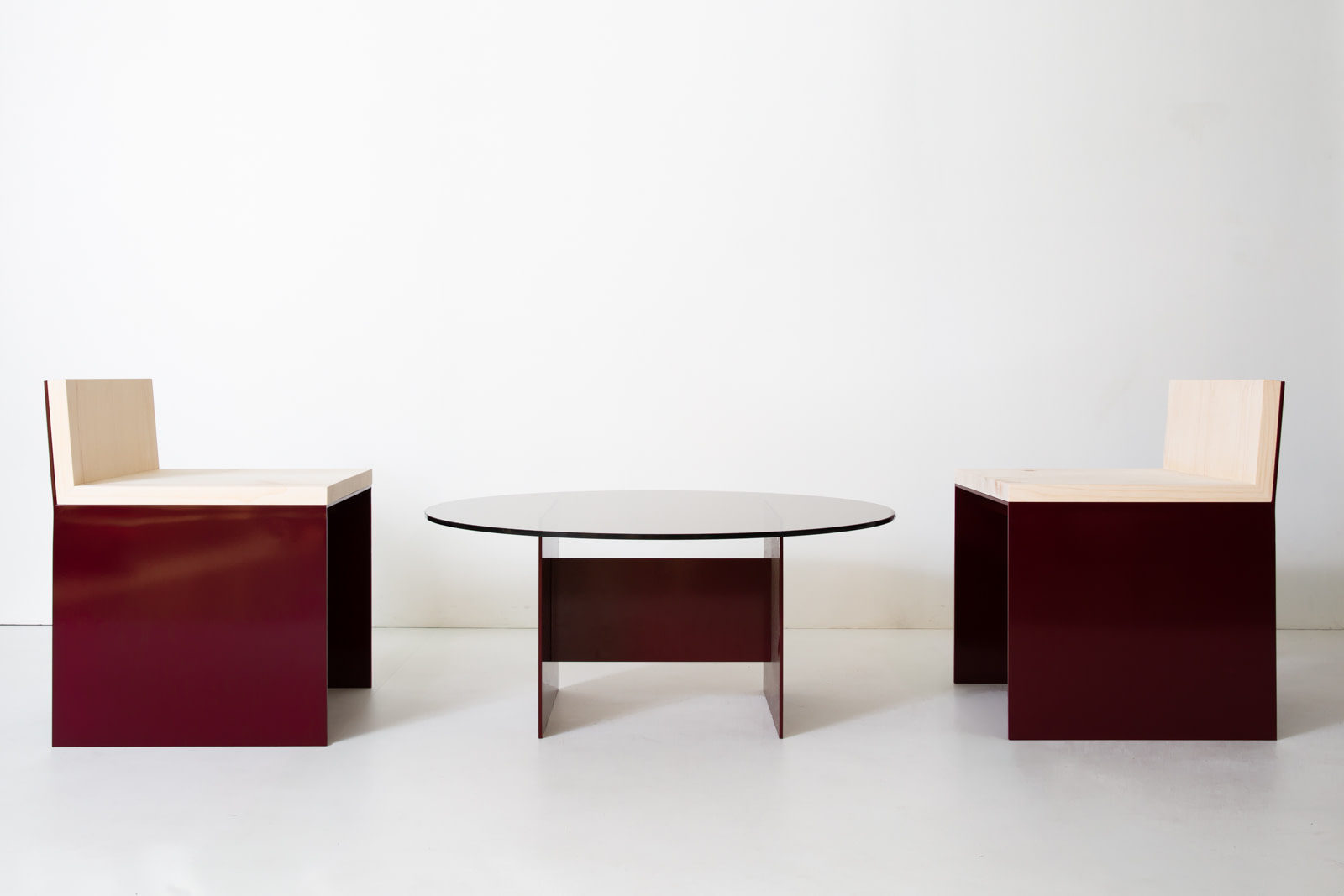 Material Studies I Dining Chair, two in oxblood aluminum and sugar pine flanking a round oxblood-based table