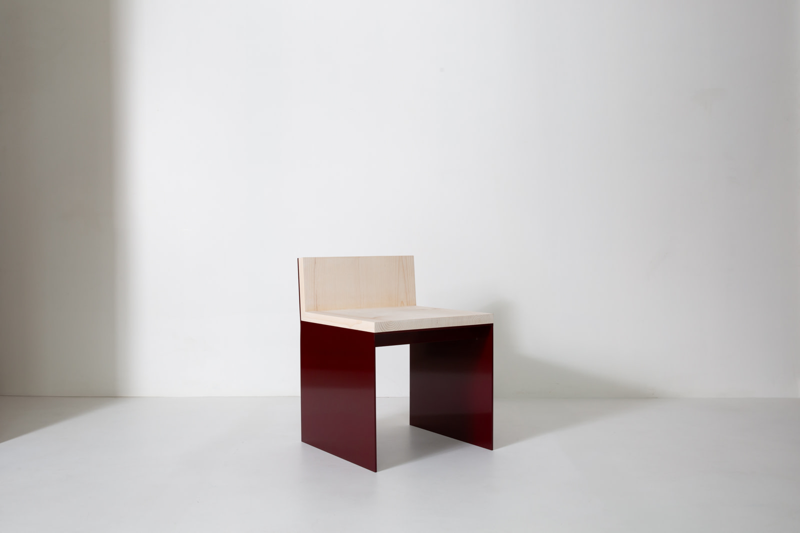 Material Studies I Dining Chair, oxblood aluminum with sugar pine seat, front-angle view in a white studio