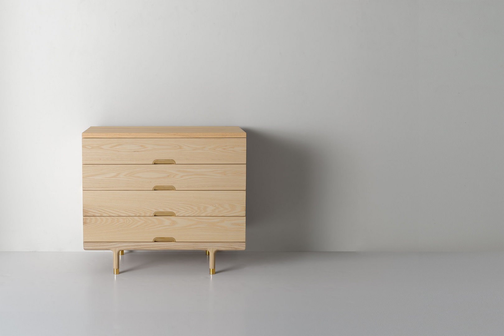 Simple Dresser Ash Simple 4 drawer Dresser in Ash with Carved Wood Finger pulls Off center Left in a Wide Frame Brass capped Legs