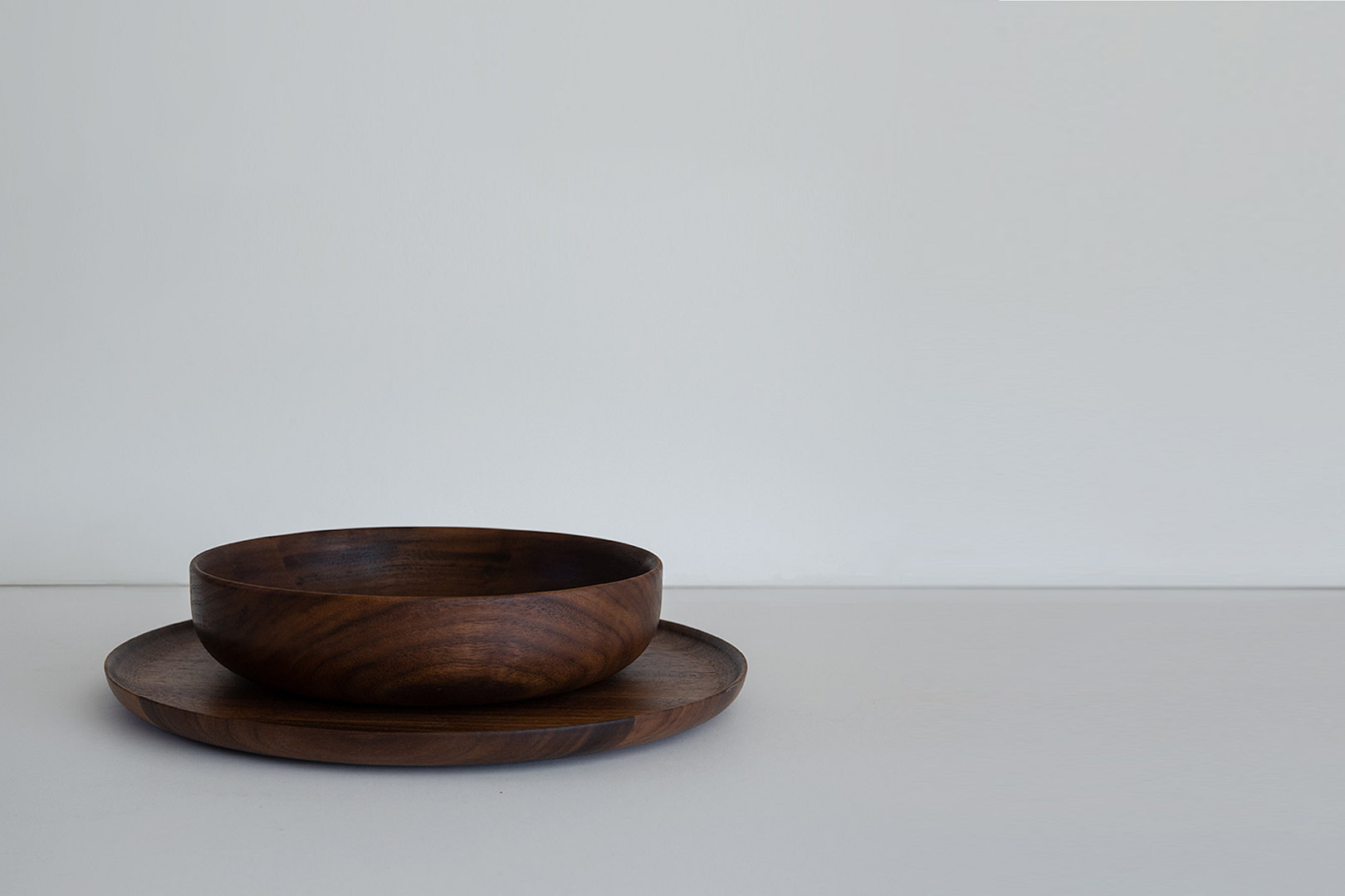 2 piece set walnut fullbleed Roasted 2 piece Set a Dark 8 inch Bowl on an 11 inch Plate Empty on a White Backdrop