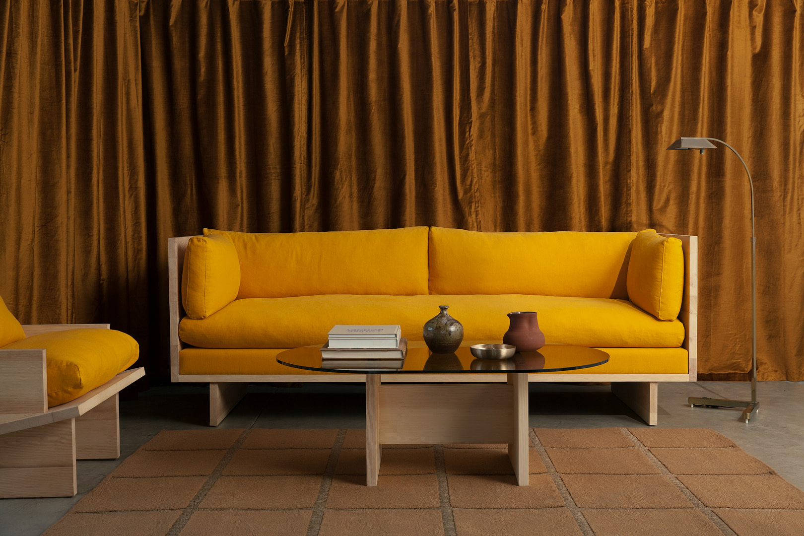 Rugosa Sofa and Chair in sugar pine with gold upholstery, Rugosa Coffee Table in front, floor lamp at right, tiled rug